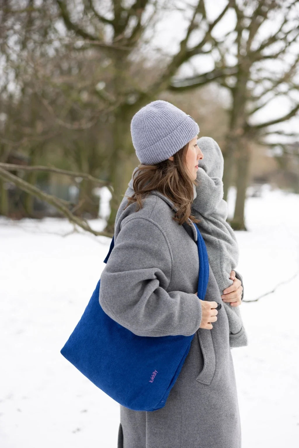 Lukkily Bag aus kobaltblauem Cordstoff als praktische Crossbodybag am langen, verstellbare Tragegurt getragen, sodass die Hände frei sind für´s Baby