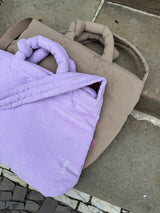 Vergleich zweier Lukkily Mom Bags: Cord Wickeltasche in Lilac und Nylon Umhängetasche in Taupe.