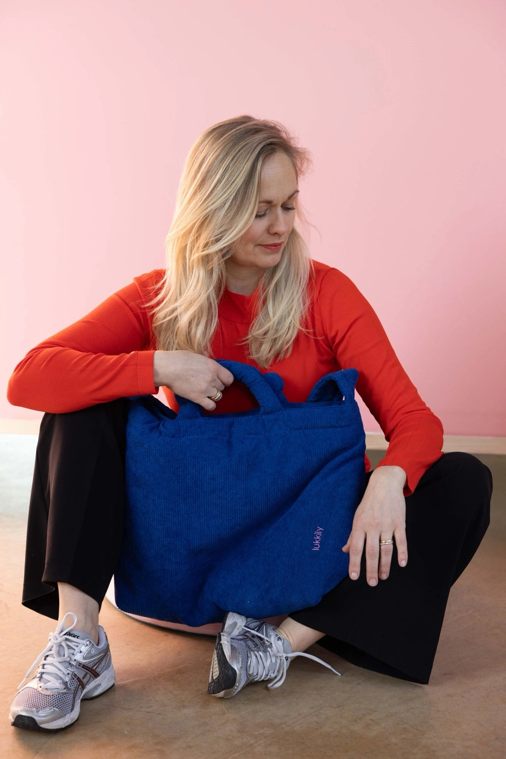 Frau sitzt mit großem royalblauen Cord Shopper im Tote-Format