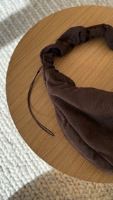 Schokoladenbraune LUKKILY Cordtasche mit weichem, gerafftem Ruffle-Henkel und verstellbarem Zugband.