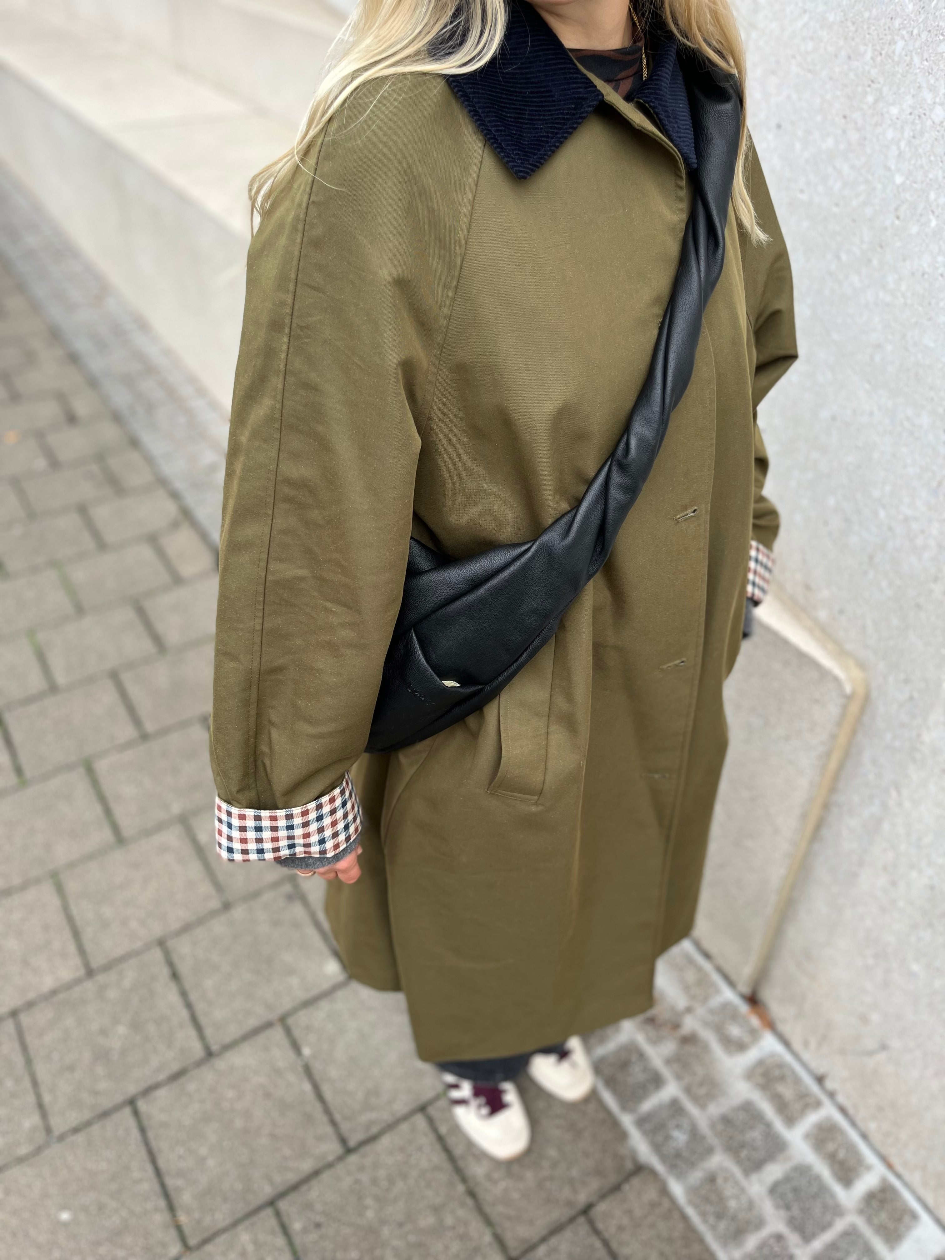 Detailaufnahme: Crossbodytasche mit gedrehtem Henkel und Außenfach mit dezentem lukkily Logo