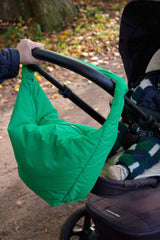 Grüne LUKKILY Nylon Wickeltasche seitlich am Kinderwagen befestigt, mit praktischen Kinderwagen-Straps für unterwegs.