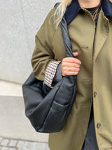 Detailaufnahme der Tasche aus softem Glattleder von Lukkily: seitliches Außenfach mit Logo und gedrehter Henkel als Designdetail