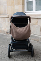 Wickeltasche mit längenverstellbarem Tragegurt aus Teddymaterial in beige am Kinderwagen