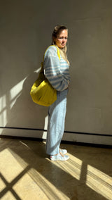 Sportive gelbe Mombag aus wasserabweisendem Nylon getragen von lukkily Gründerin Eva kombiniert mit coolem Jeanslook