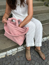Frau mit rosafarbener Cord Tote Bag als stylische Mom Bag mit längenverstellbarem Crossbody-Gurt für Alltag, Arbeit und Familienleben. 
