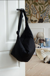 Mombag aus schwarzem, wasserabweisendem Nylon mit Kinderwagenstraps und Knoten im Henkel als Designelement