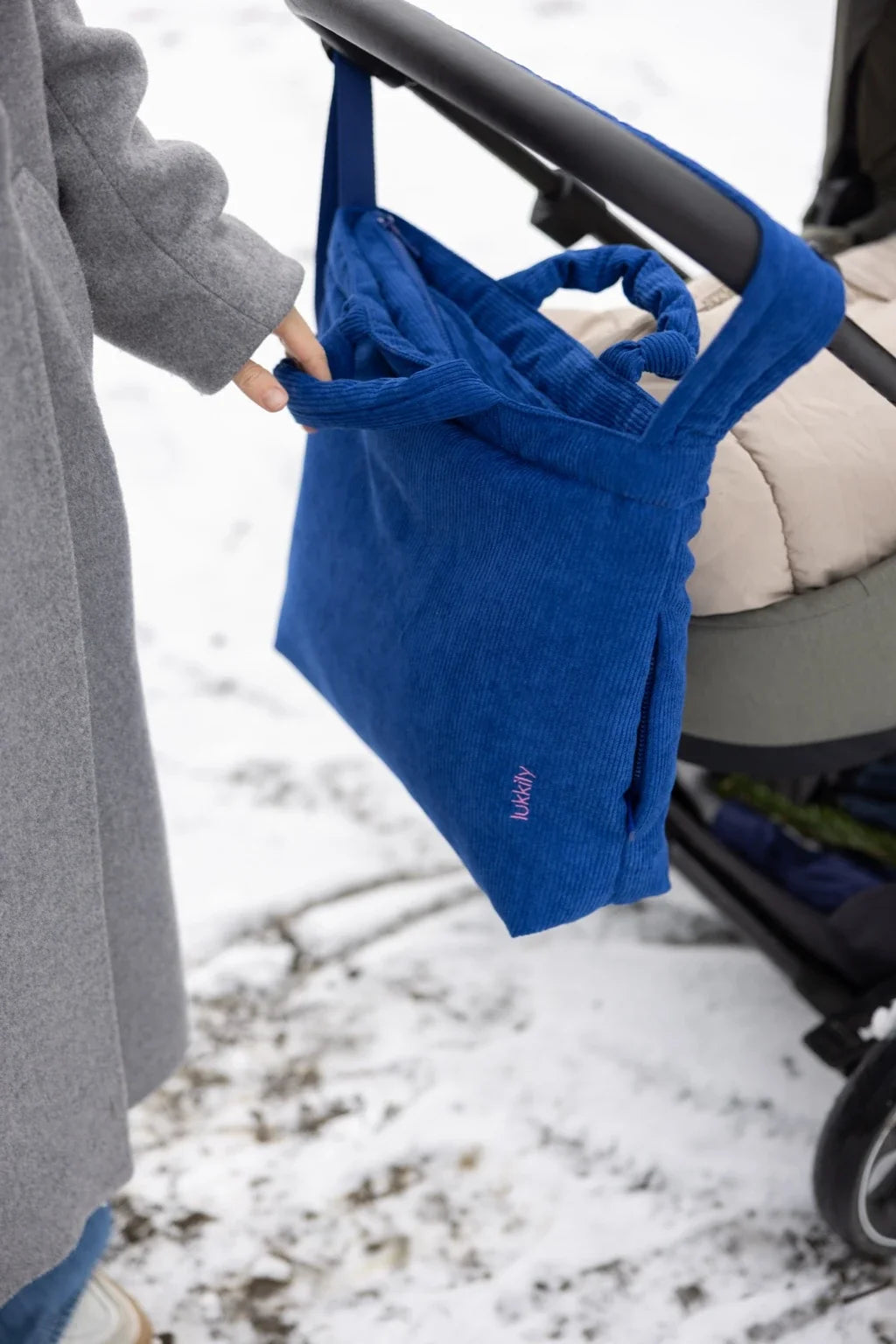 Blaue Lukkily Mombag - Wickeltasche mit Tragegriffen am Kinderwagen