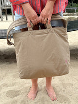 Sommerlicher Momlook mit cooler, beiger Mombag, die sich flexibel tragen lässt, auf dem Spielplatz