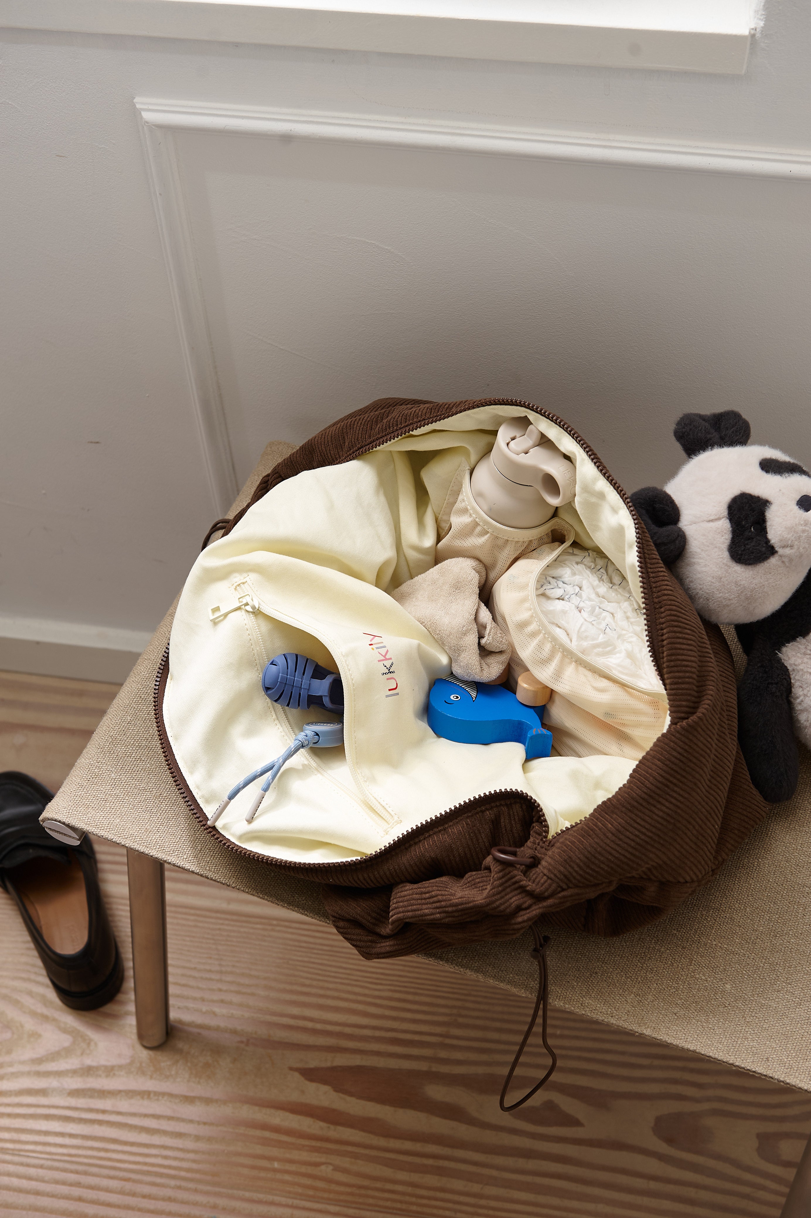Innenansicht der Mombag aus weichem braunen Cord mit praktischem Reißverschlussfach und zwei flexiblen elastischen Fächern