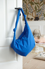 Wickeltasche aus sportivem wasserabweisendem Nylon mit Knotendetail am Henkel in kobaltblau an der Kinderzimmertür hängend - Lukkily Bag Nylon bright blue
