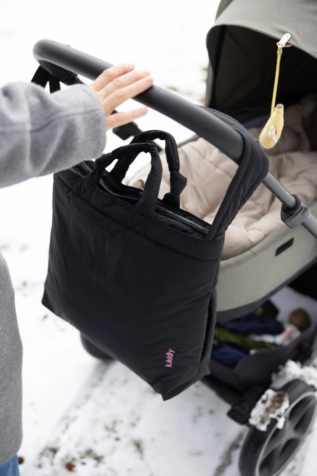 Lukkily Tote Bag black nylon -schwarze Wickeltasche aus leichtem Nylon mit Reißverschluss, pinkem lukkily Logodetail, schönem Knotendetail am Kurzgriff und längenverstellbarem, breiten Schultergurt, der perfekt an den Kinderwagenschiebebügel passt