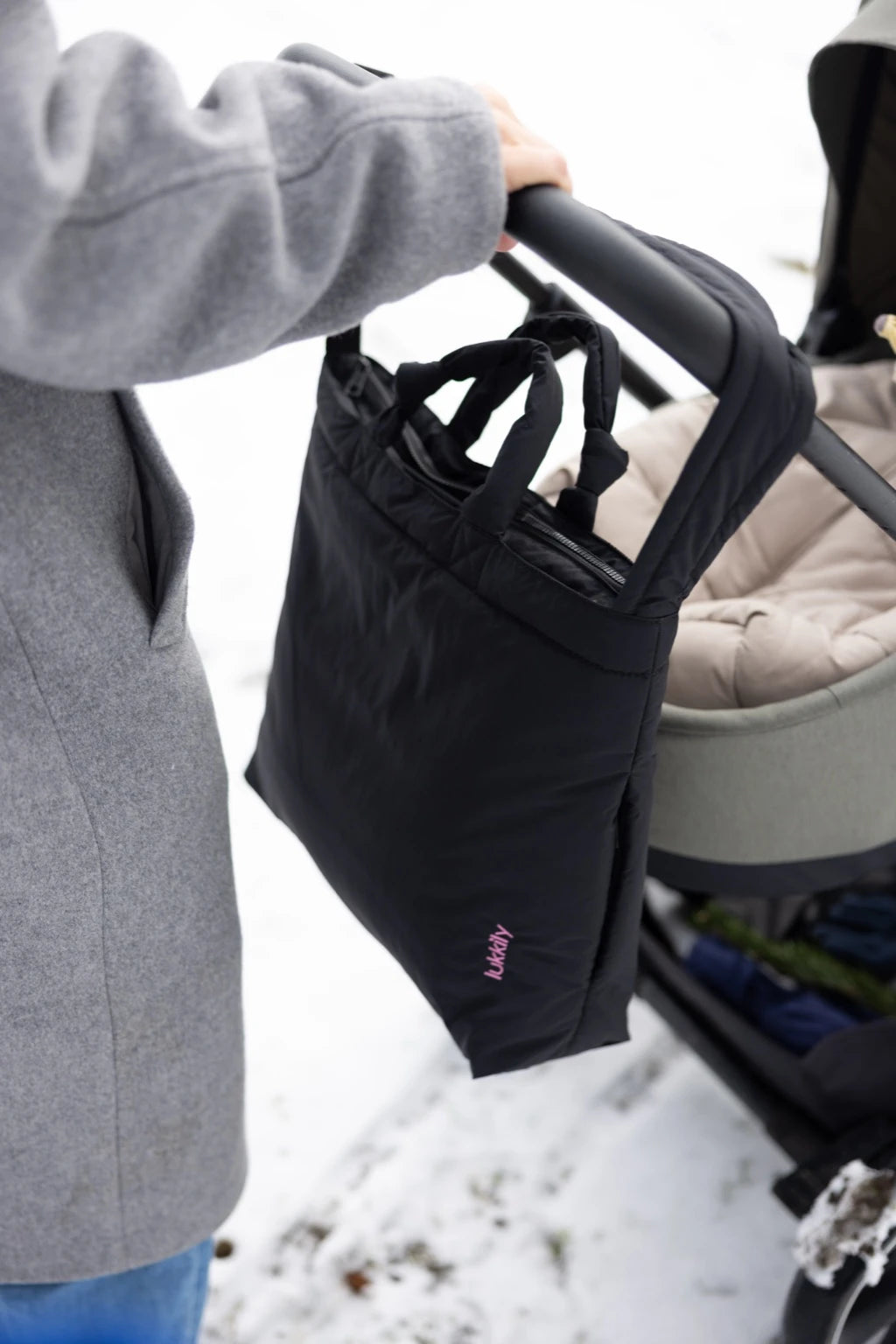 Schwarze Nylon Kinderwagentasche von Lukkily mit Reißverschluss hängt am Kinderwagen