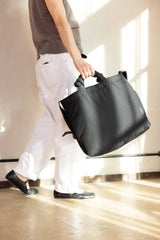 Geräumige Mom Bag aus weichem schwarzen Nylon von Lukkily mit pinker Logo-Stickerei wird beim Gehen getragen 