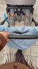 Mombag aus hellblauem Cord mit gerafftem Henkel am Kinderwagen, der von einer stylichen Mama geschoben wird