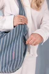 Detailansicht einer gestreiften Denim Mom Bag mit praktischem seitlichem Reißverschlussfach für Schlüssel oder kleine Gegenstände 