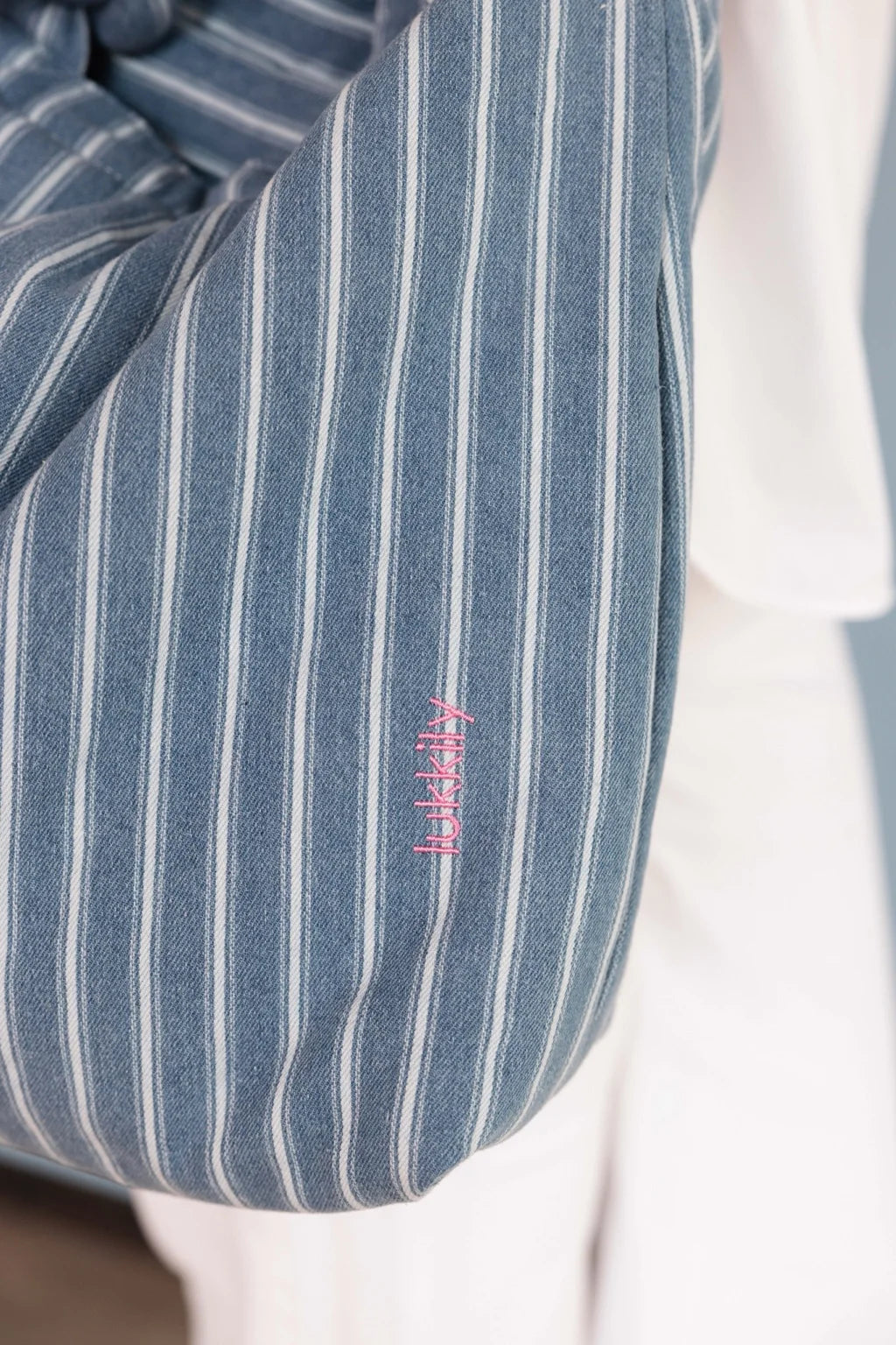 Detailaufnahme einer gestreiften Denim Mom Bag mit pinker Lukkily Logo Stickerei