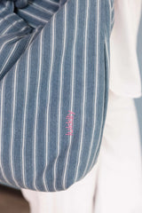 Detailaufnahme einer gestreiften Denim Mom Bag mit pinker Lukkily Logo Stickerei